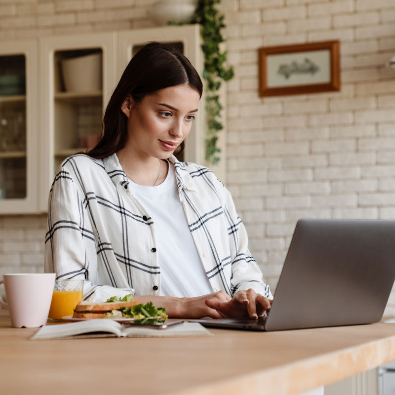 beautiful-pleased-woman-working-with-laptop-while-2022-02-01-22-37-48-utc